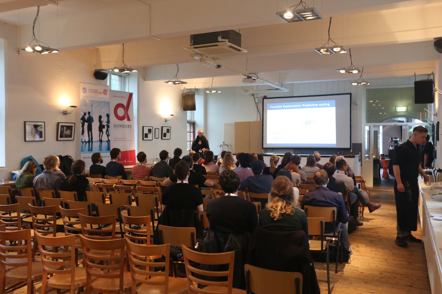 Sala piena con proiettore durante un incontro da De Hemel a Nimega