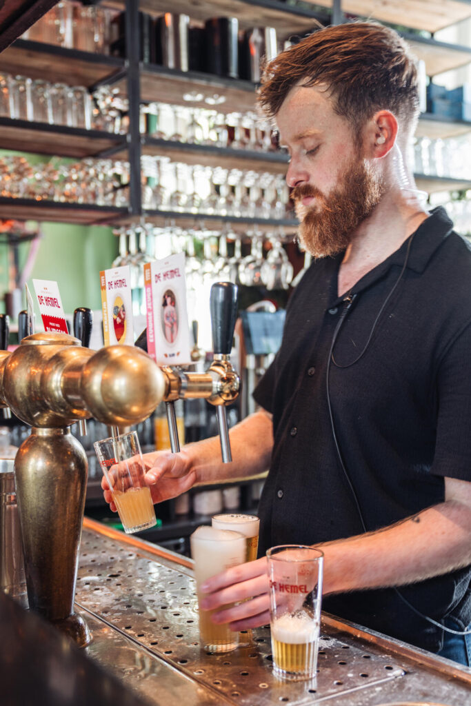 Barman tapt bier achter de bar van het Brouwerscafé van De Hemel
